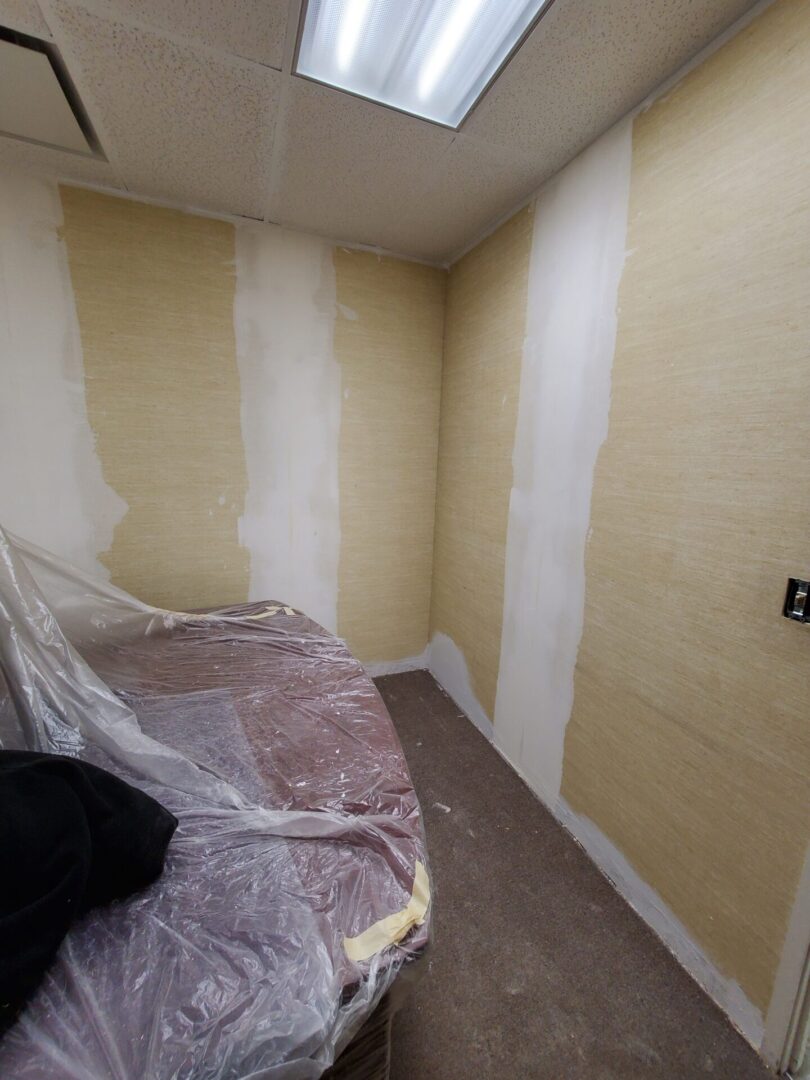 A room with walls taped off and covered in tape.