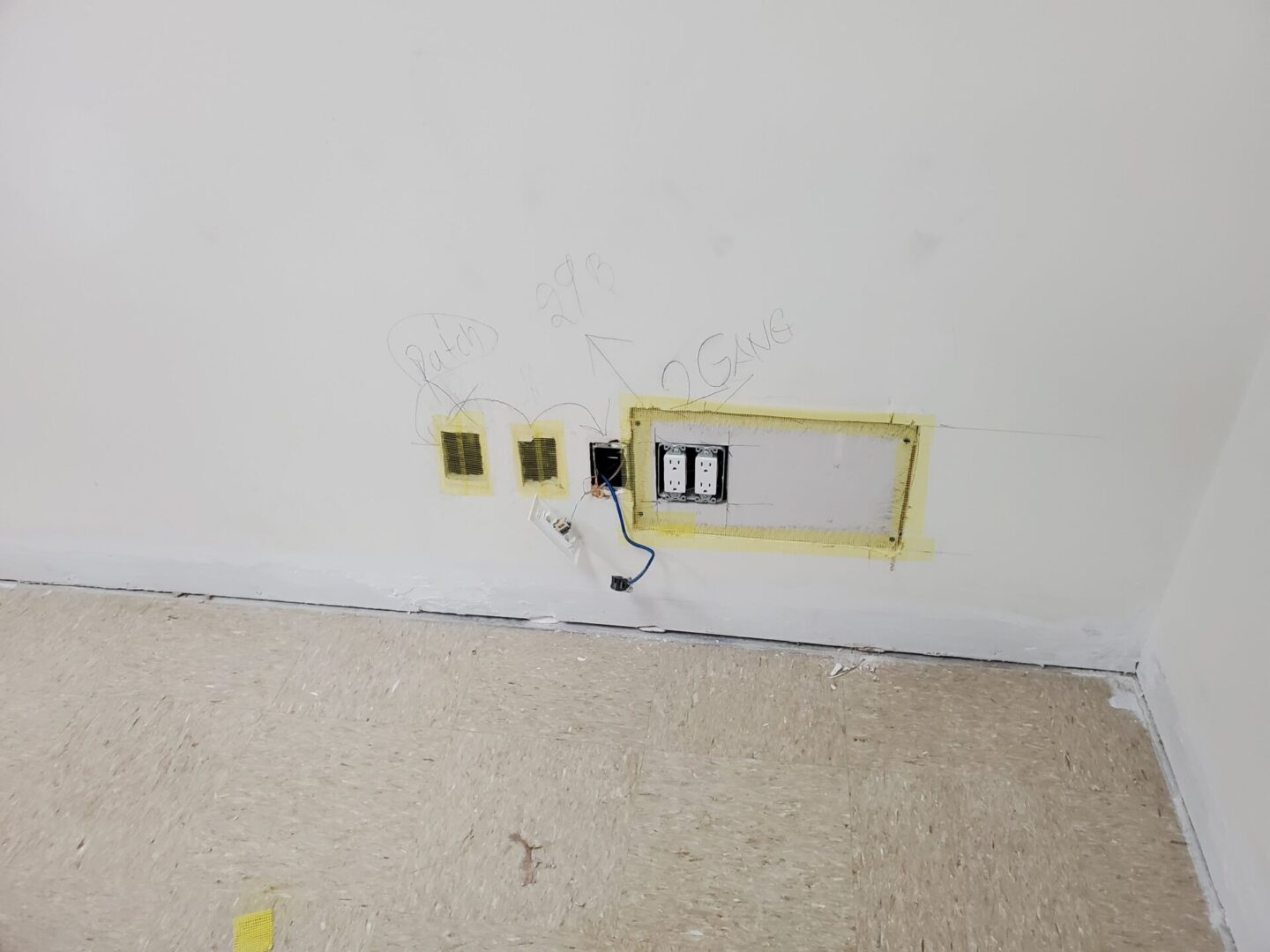 A wall with electrical wires and outlets in it.