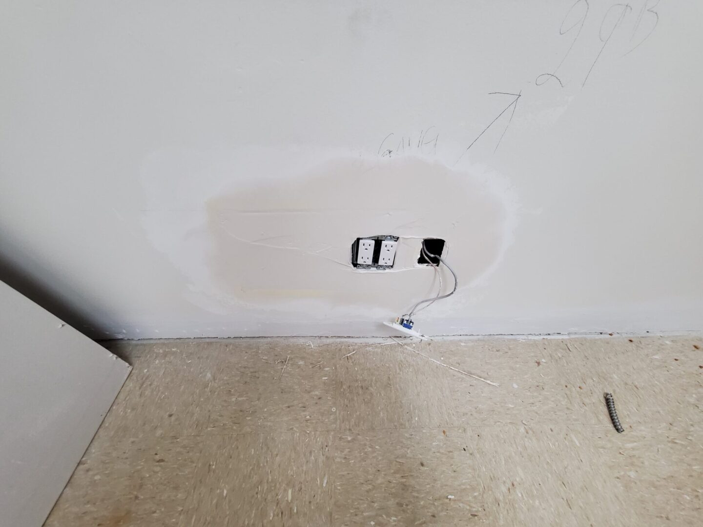 A hole in the wall with wires plugged into it.