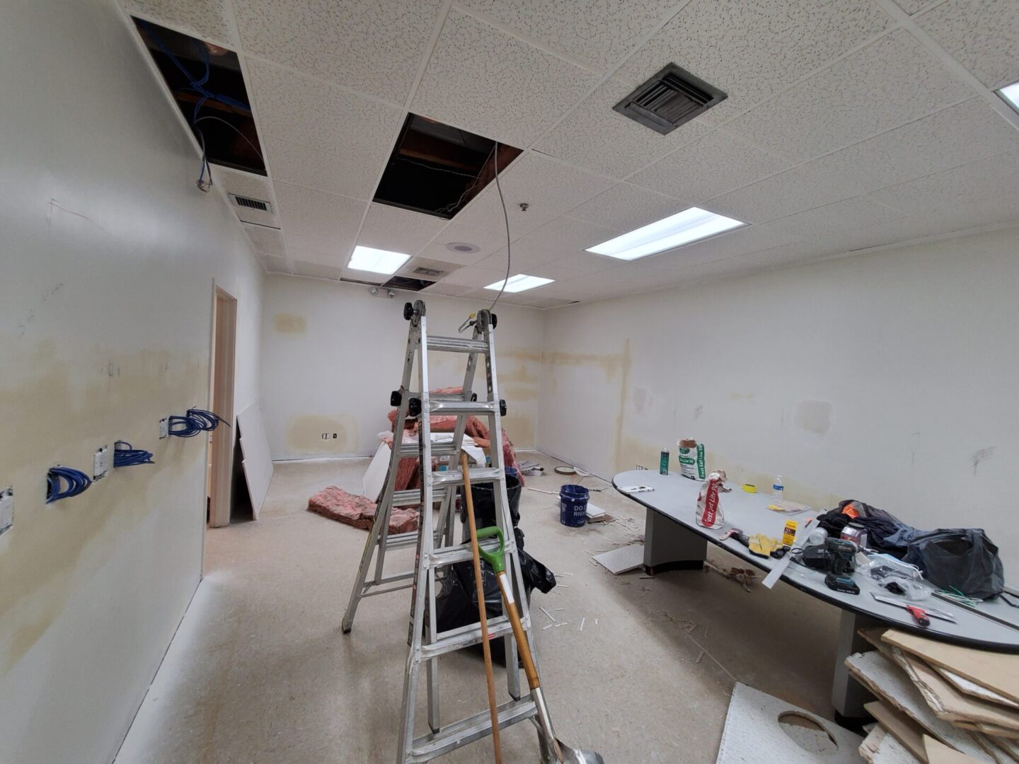 A room being remodeled with ladders and equipment.