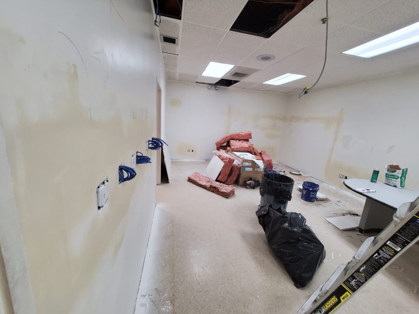 A man is laying on the floor in an empty room.