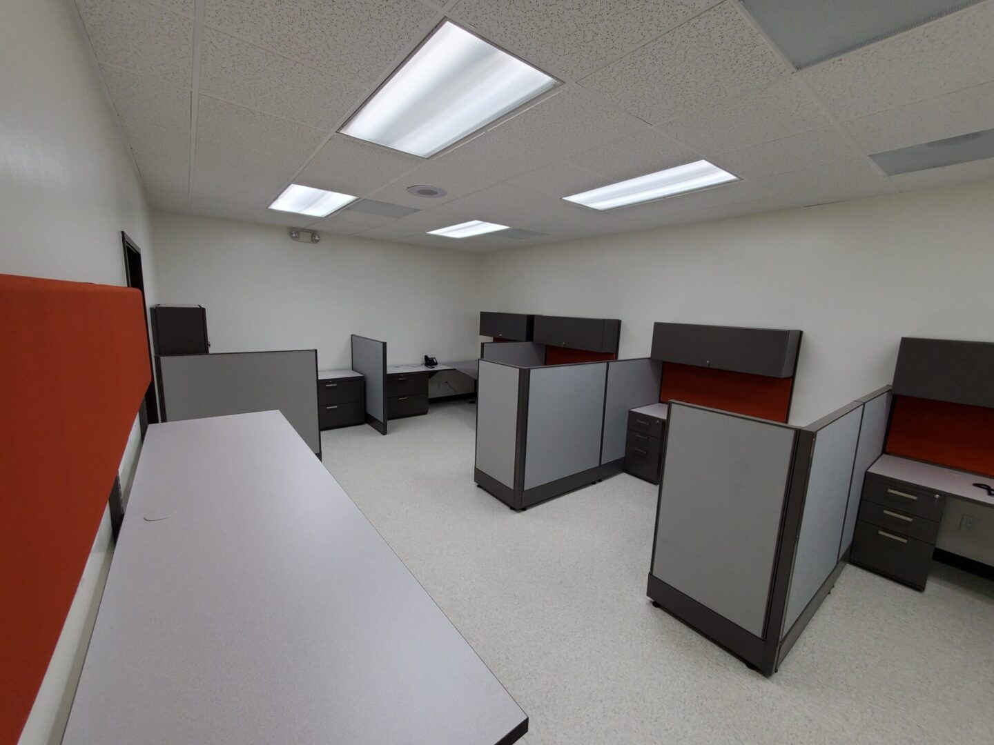 A room with many cubicles and tables in it