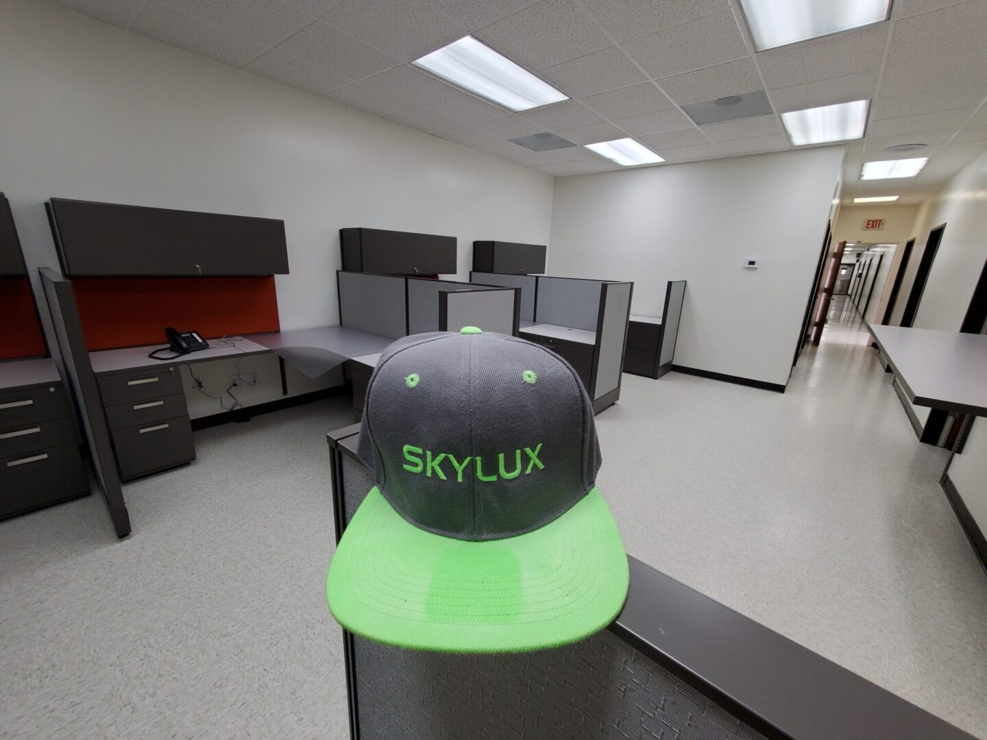 A hat is on top of the table in an office.