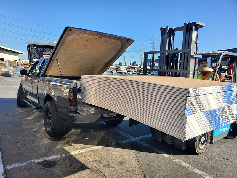 A truck with the back open and a forklift in the background.