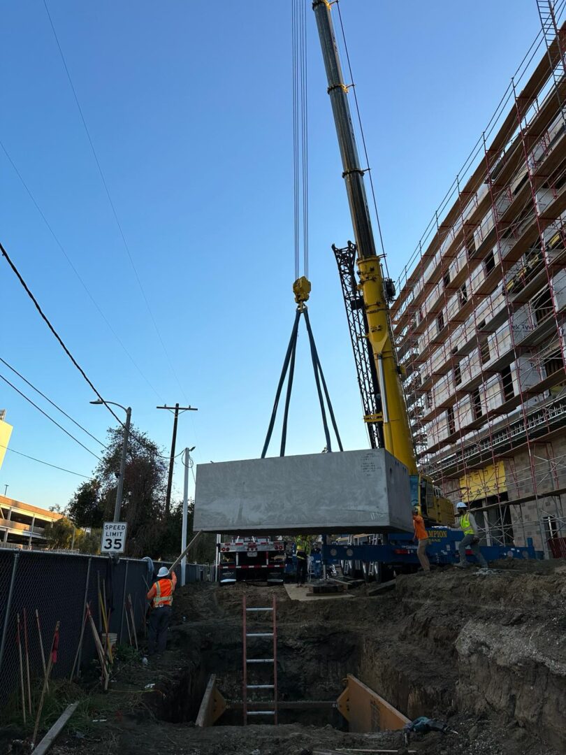 A crane is lifting a large piece of concrete.