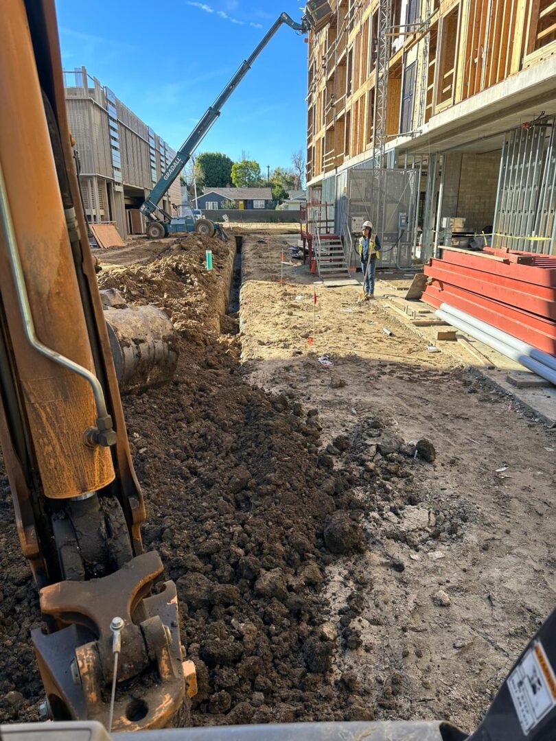 A construction site with a pile of dirt and a crane.