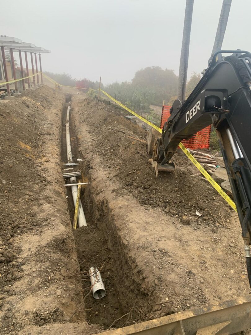 A black and yellow tractor is digging in the ground