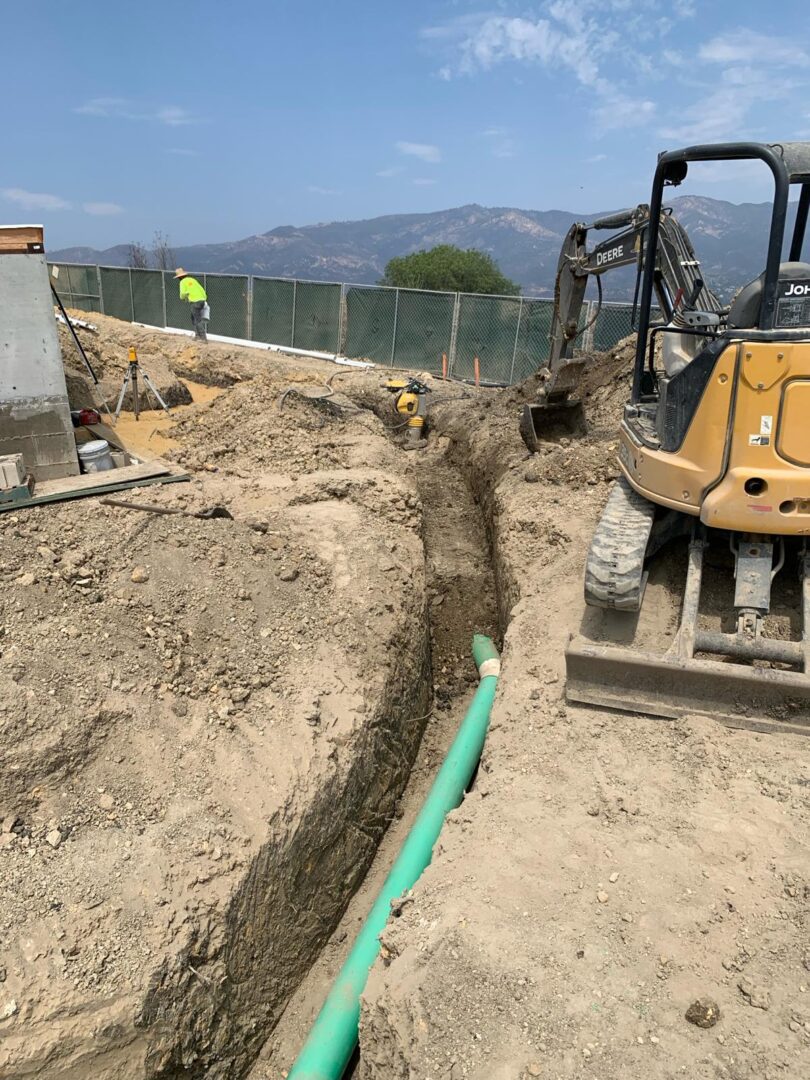 A yellow tractor is digging in the ground