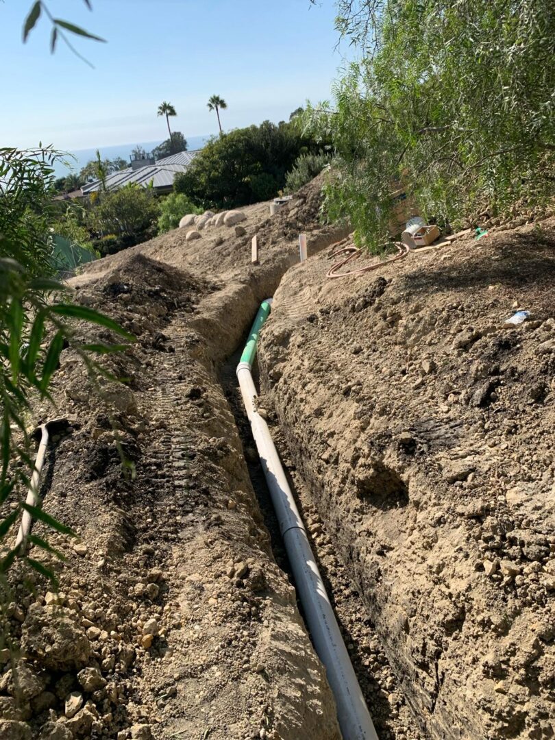 A pipe laying in the ground on top of a hill.