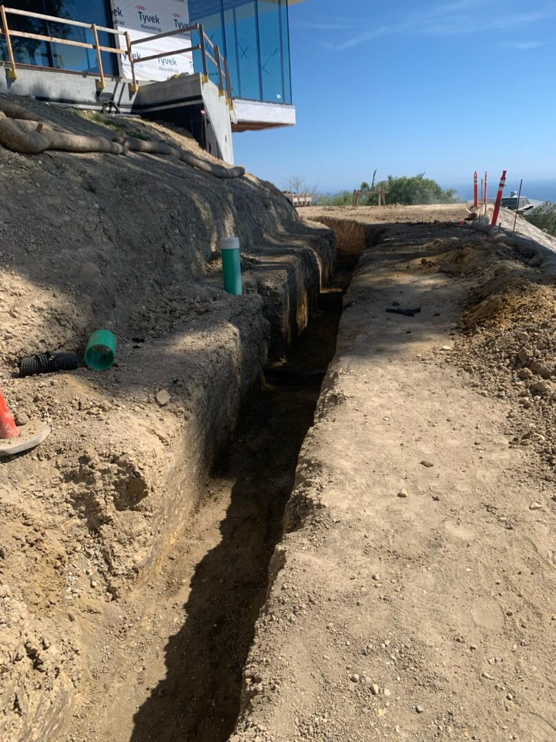 A trench is shown with pipes and wires.